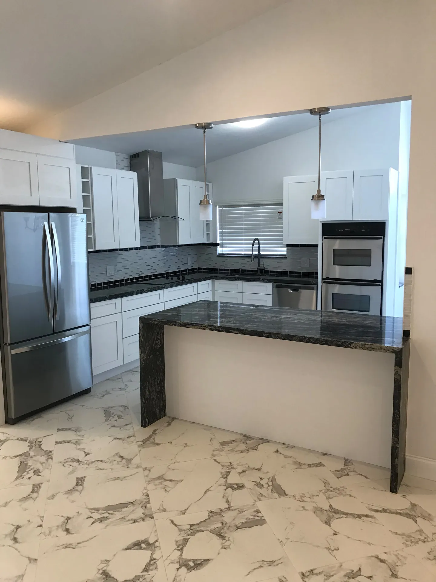 Open kitchen with stone waterfall island