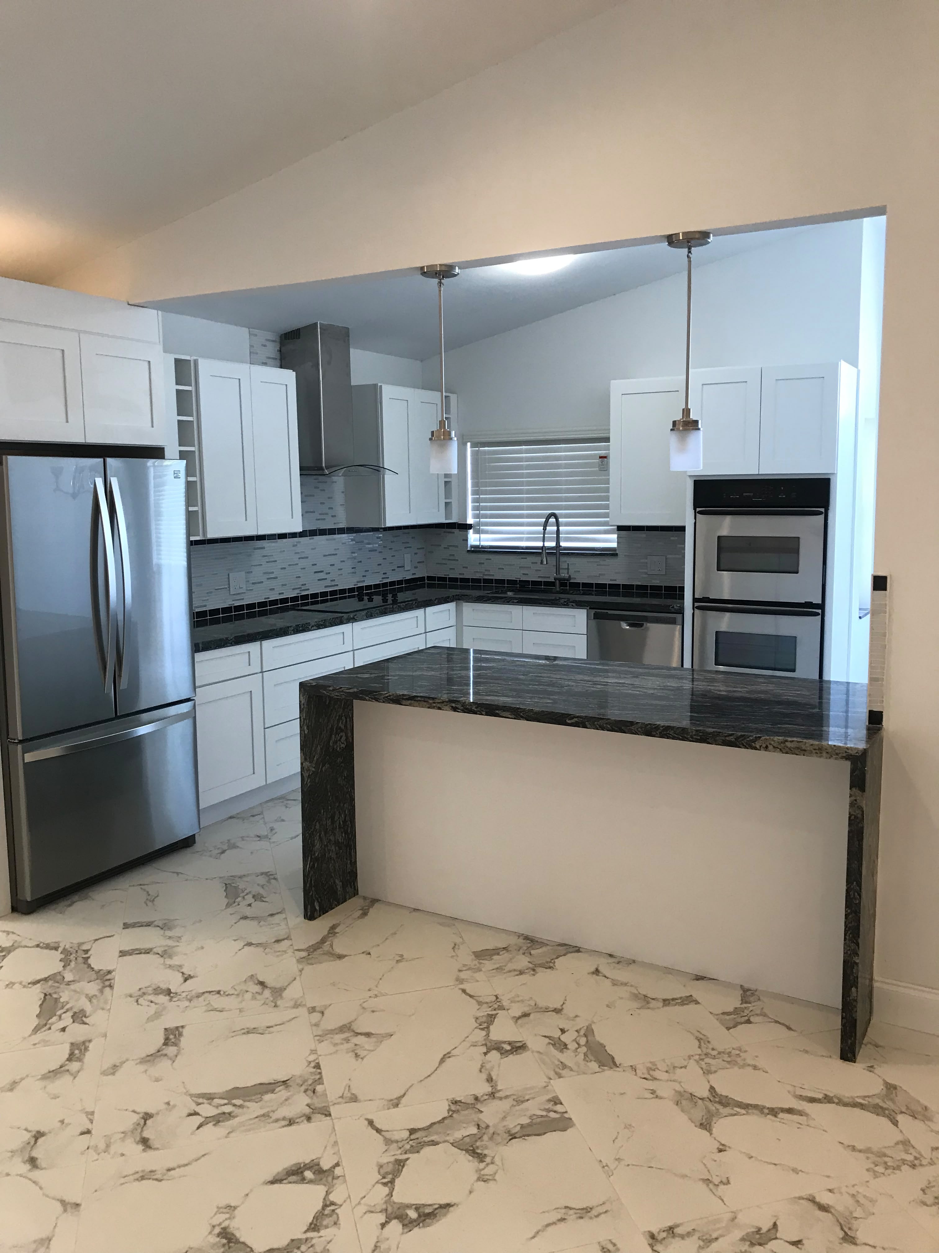 Open kitchen with stone waterfall island