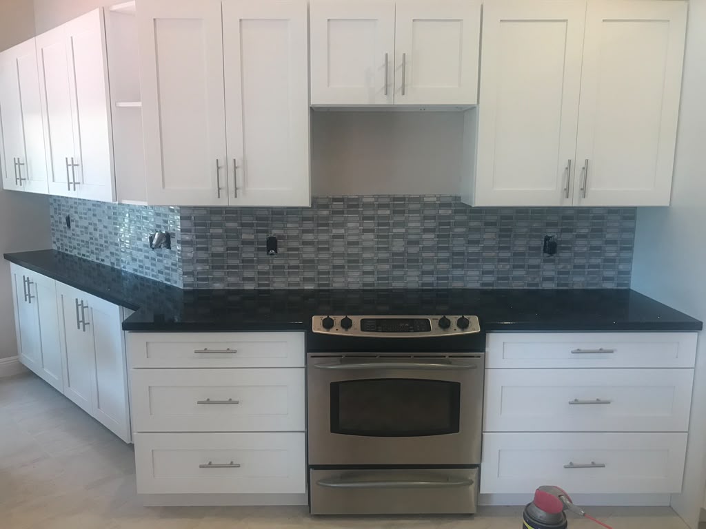 White shaker kitchen with dark stone counters